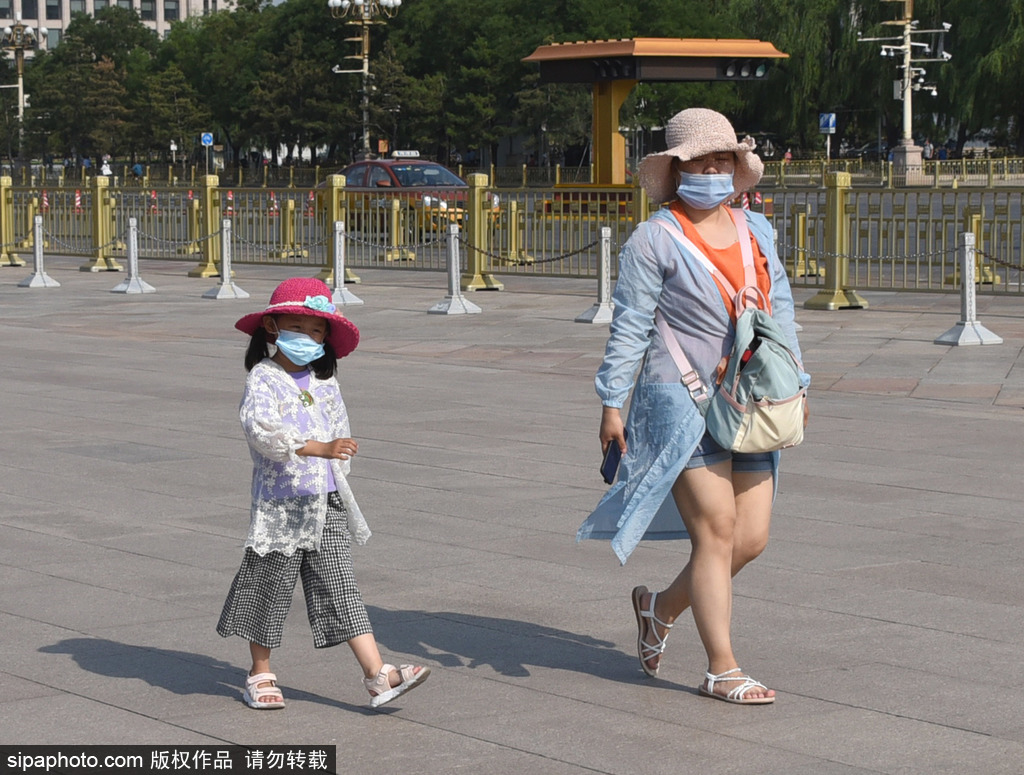 北京持续高温暴晒天气，游客撑伞顶烈日出行游览