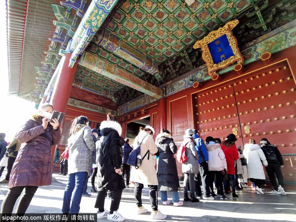 游客排队从门缝里拍天坛祈年殿